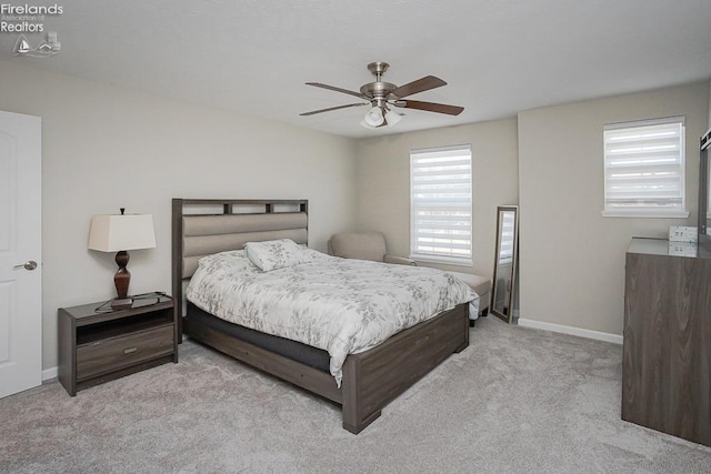 carpeted bedroom with ceiling fan and baseboards