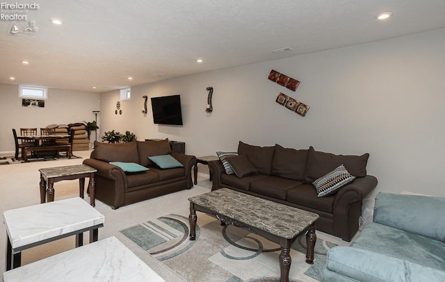 living room featuring recessed lighting, light colored carpet, and a textured ceiling