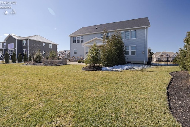 back of house featuring a residential view, a lawn, and fence