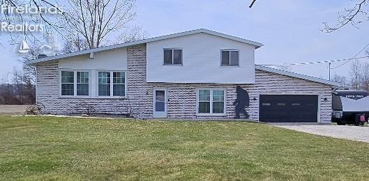 5041 State Route 99, Monroeville, OH 44847 - tri-level home featuring an attached garage, concrete driveway, and a front lawn