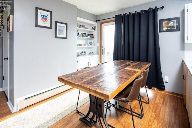 5041 State Route 99, Monroeville, OH 44847 - dining space featuring baseboard heating, light wood-style flooring, baseboards, and built in features