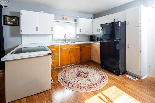 5041 State Route 99, Monroeville, OH 44847 - kitchen featuring visible vents, light wood-style flooring, freestanding refrigerator, a sink, and light countertops