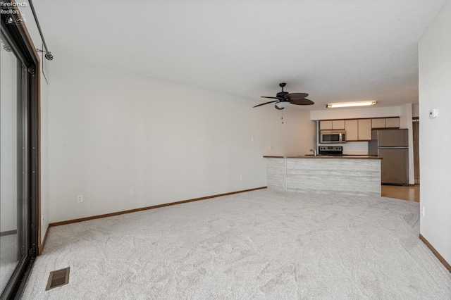 1789 N Windward Dr, Port Clinton, OH 43452 - unfurnished living room featuring light colored carpet, a ceiling fan, visible vents, and baseboards