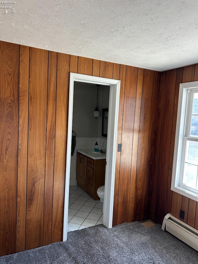 424 N Ridge Rd, Willard, OH 44890 - unfurnished bedroom with a textured ceiling, multiple windows, baseboard heating, and a sink