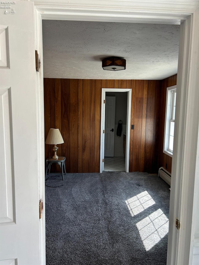 424 N Ridge Rd, Willard, OH 44890 - interior space with a baseboard radiator, carpet floors, wooden walls, and a textured ceiling