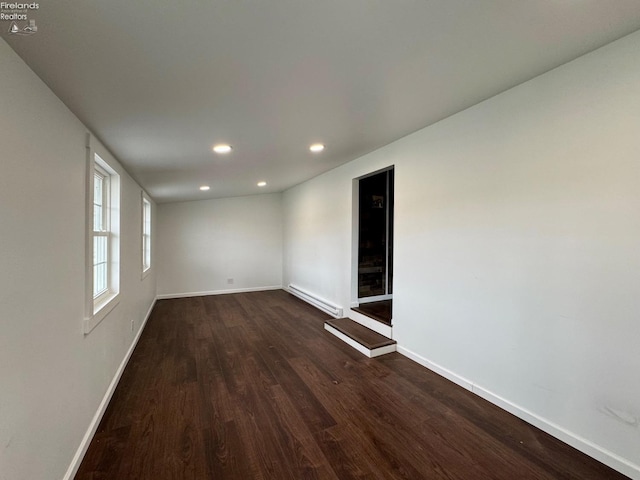 empty room with recessed lighting, baseboards, dark wood-style flooring, and a baseboard radiator