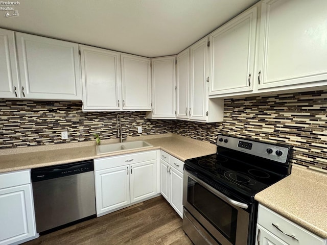 kitchen featuring dark wood-style floors, white cabinets, stainless steel appliances, and a sink