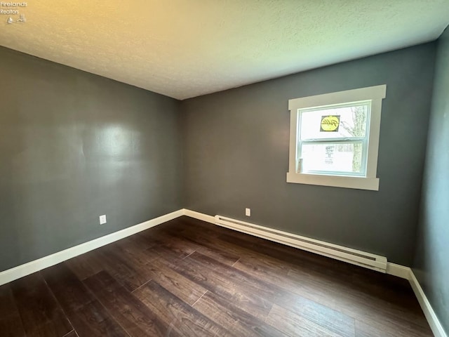 empty room featuring a baseboard radiator, baseboards, a textured ceiling, and dark wood-style floors