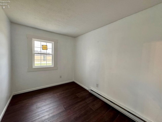 empty room featuring dark wood finished floors, a textured ceiling, baseboards, and a baseboard radiator