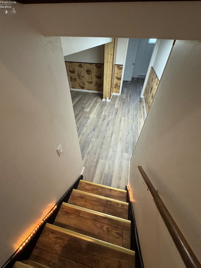 stairway with baseboards and wood finished floors