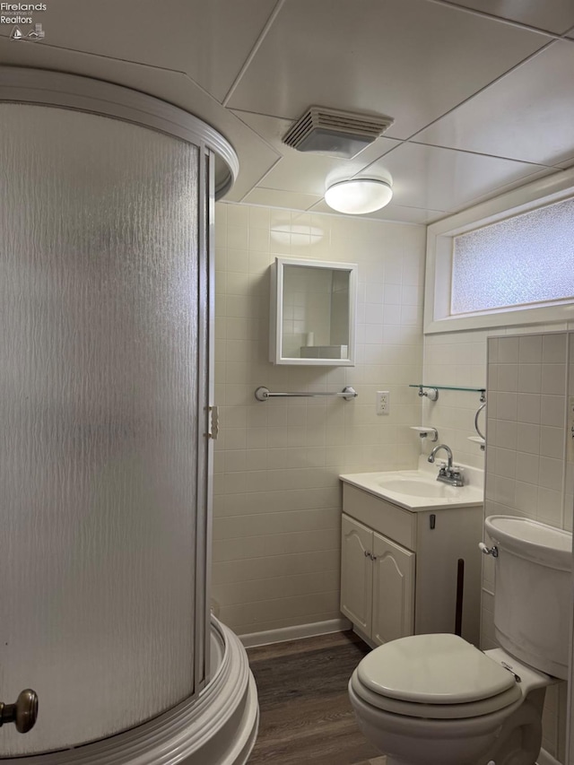 bathroom featuring vanity, a shower stall, toilet, and visible vents