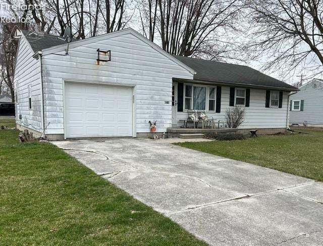 ranch-style home featuring driveway, an attached garage, and a front lawn