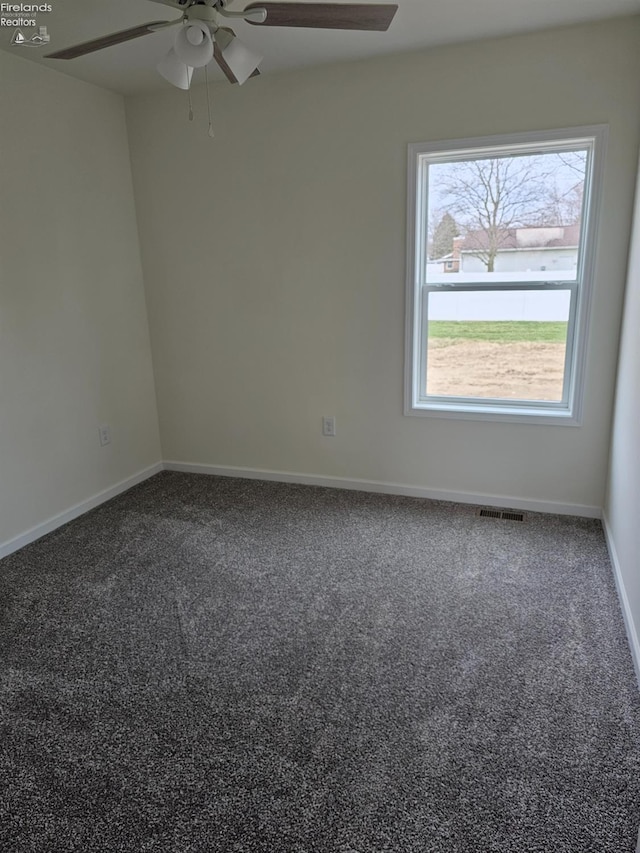 empty room with baseboards, visible vents, ceiling fan, and carpet flooring