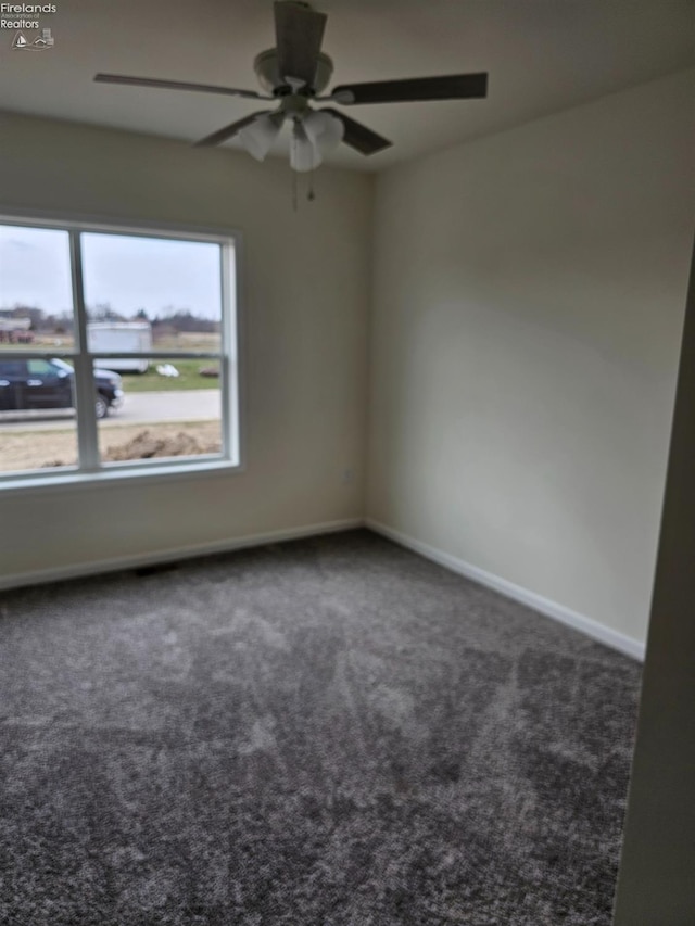 carpeted spare room with baseboards and ceiling fan