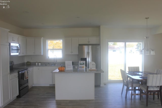 kitchen with white cabinets, a sink, a center island, and appliances with stainless steel finishes