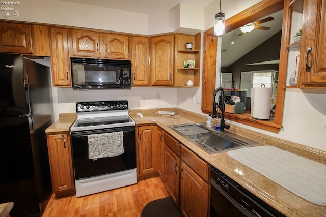 kitchen featuring a sink, light countertops, light wood-type flooring, brown cabinets, and black appliances