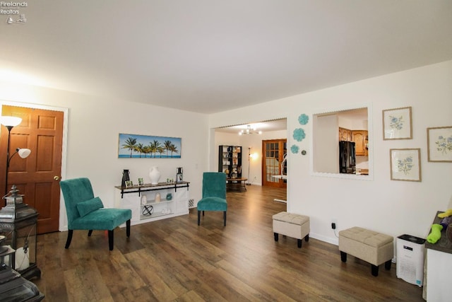 living area featuring wood finished floors and an inviting chandelier