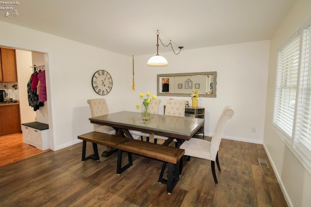 dining room featuring visible vents, dark wood-style flooring, and plenty of natural light