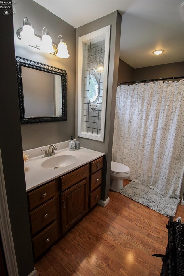 full bath with vanity, toilet, and wood finished floors
