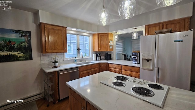 kitchen with decorative backsplash, a baseboard radiator, white appliances, a sink, and brown cabinetry