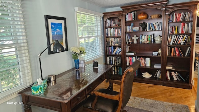 office area with a textured ceiling and wood finished floors