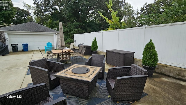view of patio featuring an outdoor structure, fence, outdoor dining area, a garage, and outdoor lounge area