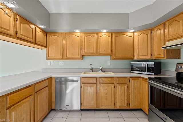 kitchen with light countertops, stainless steel appliances, under cabinet range hood, a sink, and light tile patterned floors