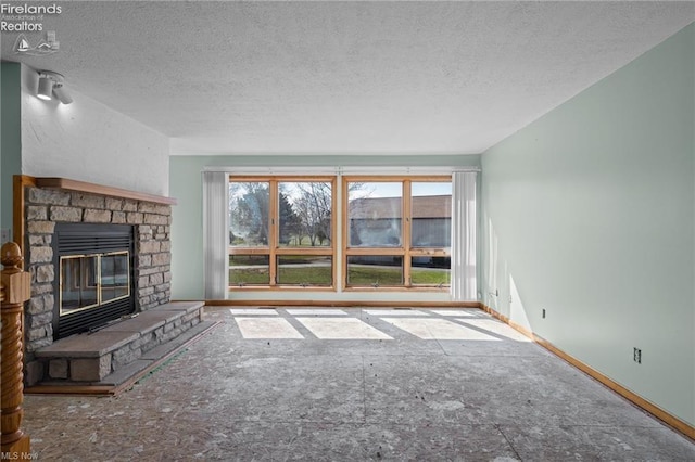 unfurnished living room featuring baseboards, a fireplace, and a textured ceiling