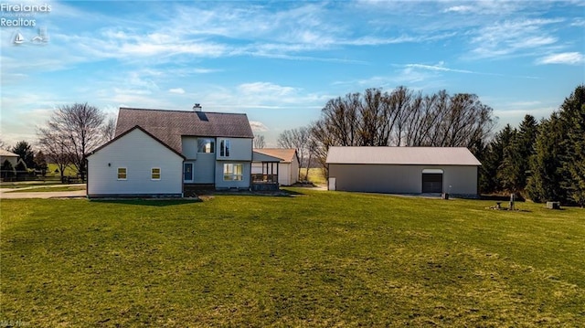 rear view of property featuring an outbuilding and a yard