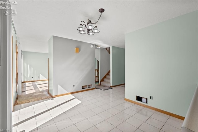 interior space featuring baseboards, stairs, an inviting chandelier, and tile patterned flooring