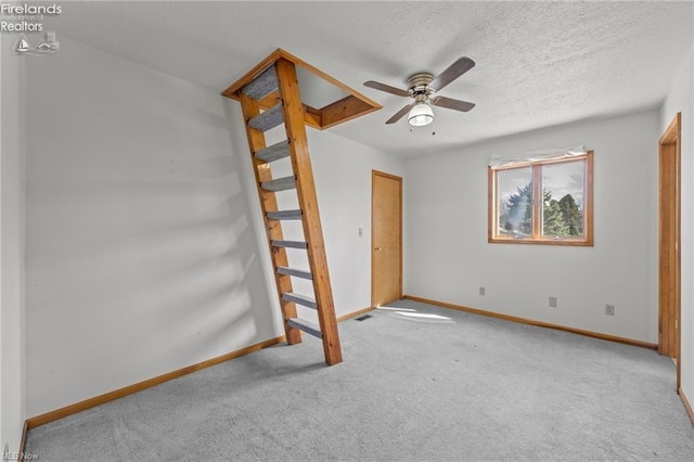 unfurnished bedroom with baseboards, a ceiling fan, carpet flooring, and a textured ceiling