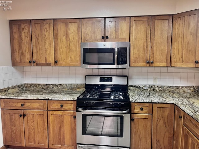6276 County Road 33, Helena, OH 43435 - kitchen with tasteful backsplash, light stone countertops, appliances with stainless steel finishes, and brown cabinets