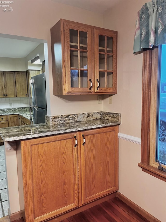 6276 County Road 33, Helena, OH 43435 - kitchen featuring stone counters, dark wood-style flooring, glass insert cabinets, freestanding refrigerator, and brown cabinets