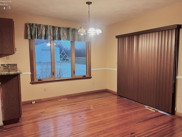 6276 County Road 33, Helena, OH 43435 - unfurnished dining area with a chandelier, wood finished floors, baseboards, and visible vents