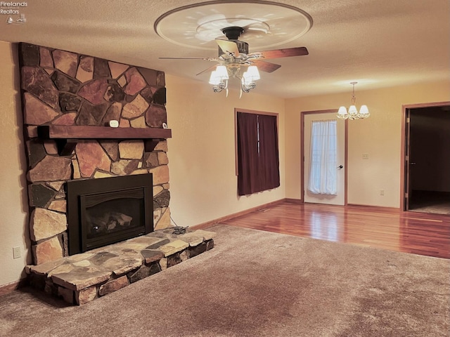 6276 County Road 33, Helena, OH 43435 - unfurnished living room featuring ceiling fan with notable chandelier, a fireplace, a textured ceiling, wood finished floors, and carpet flooring