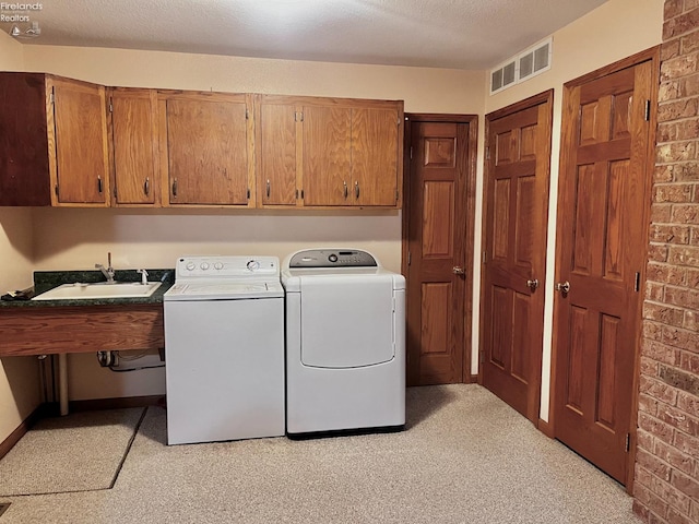 6276 County Road 33, Helena, OH 43435 - laundry area featuring visible vents, washer and dryer, a sink, a textured ceiling, and cabinet space