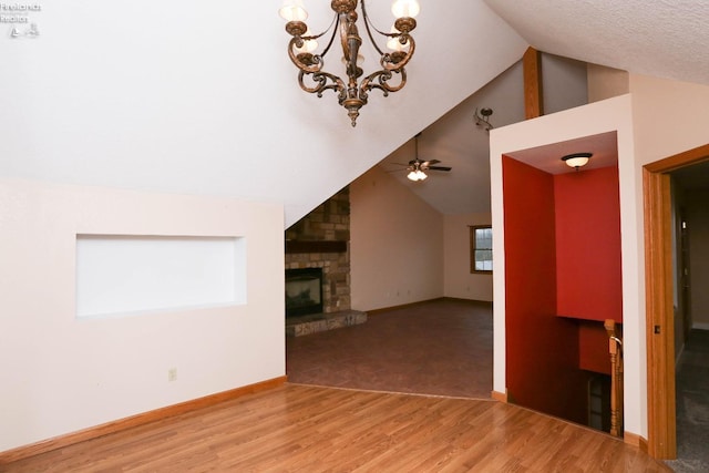 6276 County Road 33, Helena, OH 43435 - unfurnished living room featuring wood finished floors, ceiling fan with notable chandelier, baseboards, and a stone fireplace