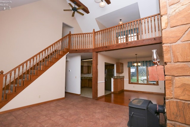 6276 County Road 33, Helena, OH 43435 - unfurnished living room featuring baseboards, stairs, a towering ceiling, and ceiling fan with notable chandelier
