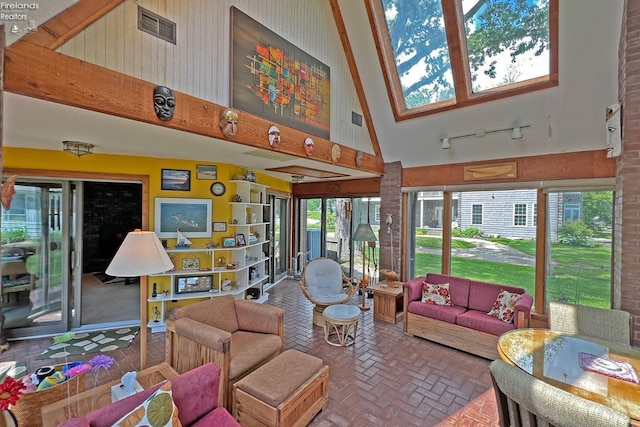 208 Johanna Ln, Kelleys Island, OH 43438 - living room with visible vents, track lighting, a towering ceiling, and brick floor