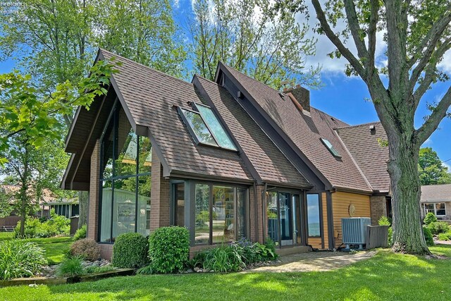 208 Johanna Ln, Kelleys Island, OH 43438 - rear view of property featuring a lawn, a chimney, and a shingled roof