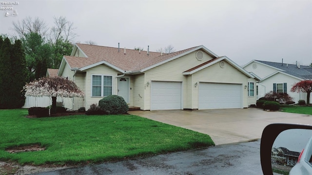 100 Grand Ave, Clyde, OH 43410 - ranch-style home featuring a front yard, driveway, roof with shingles, and an attached garage