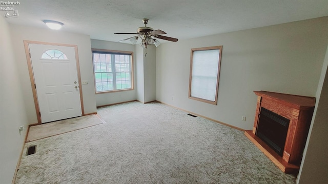 100 Grand Ave, Clyde, OH 43410 - unfurnished living room with carpet floors, a fireplace, baseboards, visible vents, and ceiling fan