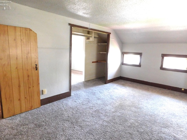 29 Walker St, Tiffin, OH 44883 - unfurnished bedroom featuring a textured ceiling, vaulted ceiling, baseboards, a closet, and carpet floors