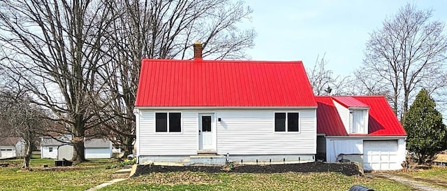 view of front of property with a garage, metal roof, and entry steps
