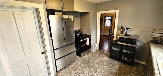 kitchen with a textured ceiling and appliances with stainless steel finishes