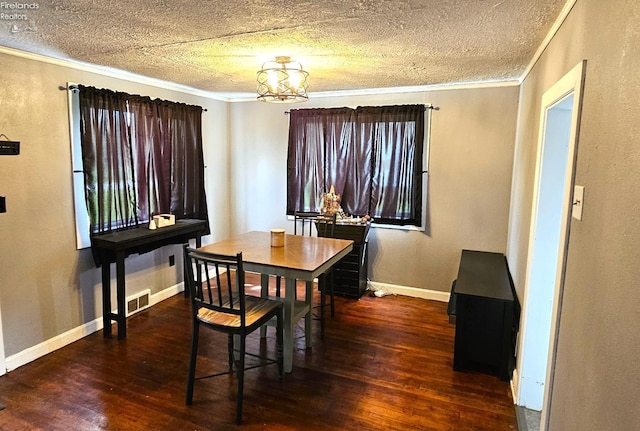 dining space with ornamental molding, visible vents, an inviting chandelier, and hardwood / wood-style floors