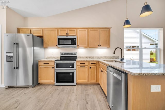 kitchen with light wood finished floors, stainless steel appliances, light brown cabinetry, and a sink
