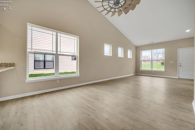 unfurnished living room featuring high vaulted ceiling, ceiling fan, baseboards, and wood finished floors