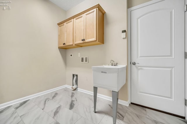 washroom featuring marble finish floor, hookup for an electric dryer, baseboards, cabinet space, and washer hookup