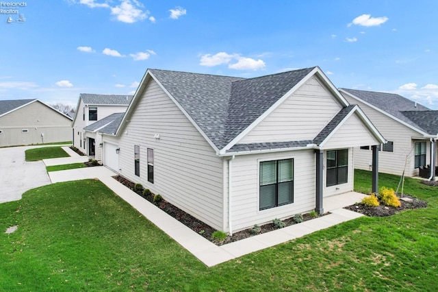 view of home's exterior with roof with shingles and a yard